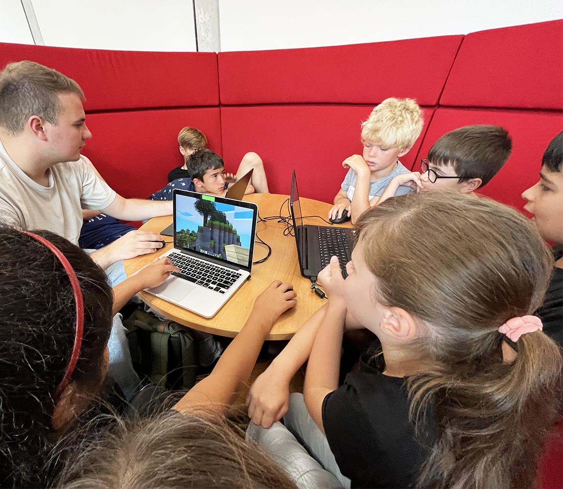 Grundschüler:innen gestalten Spiele gemeinsam mit Studierenden mit Minetest am Laptop