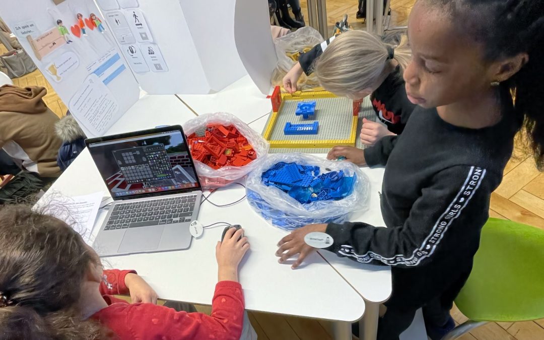 Schülerinnen entwickeln Spiel gemeinsam am Tisch mit Lego und Minetest